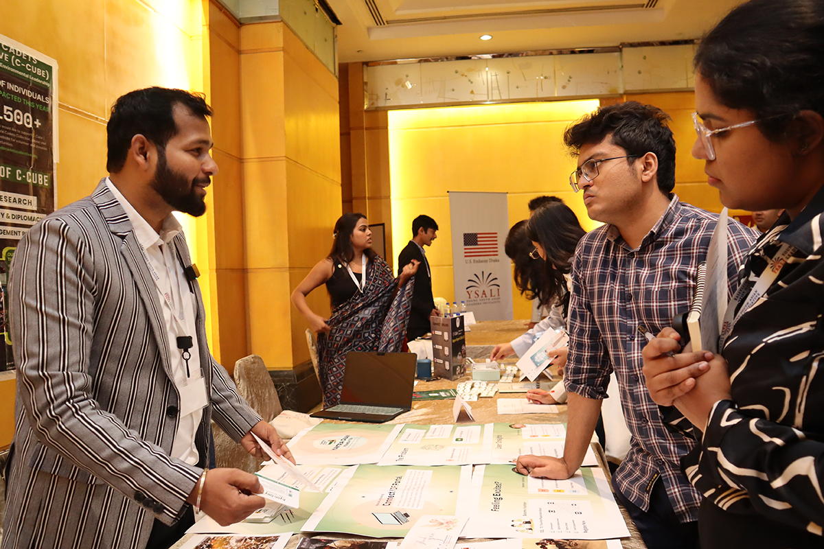 Man speaks to visitors at a tabling event.