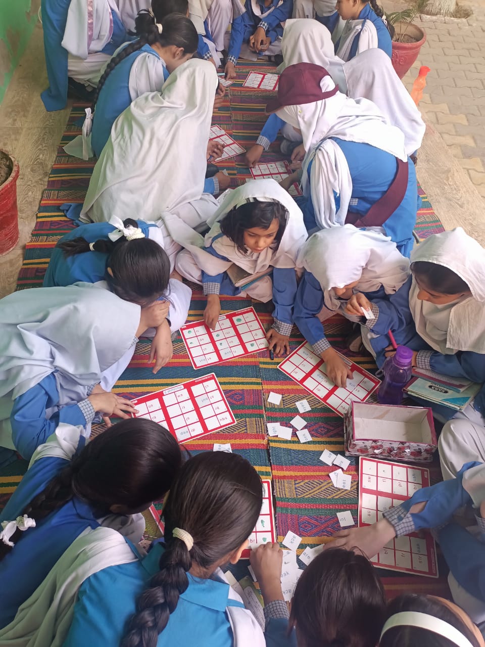 Students sit on the floor playing a word game.