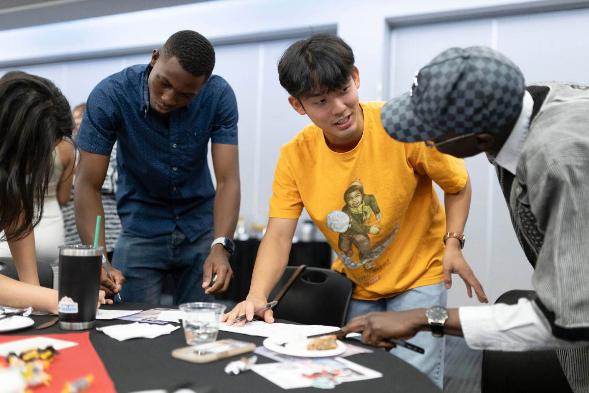 A group of students works together to fill out an activity sheet.