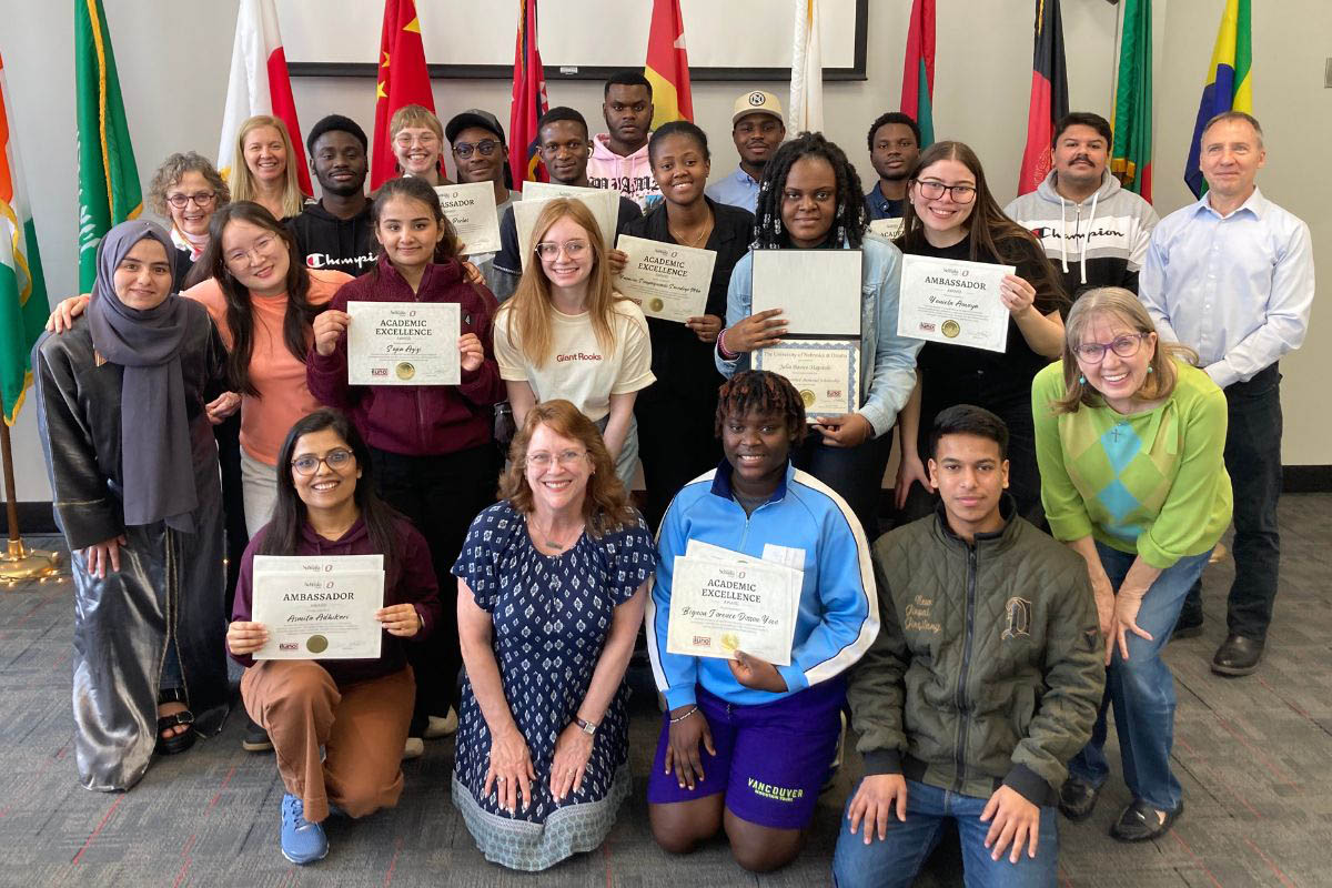 International students pose with certificates earned in their programs.
