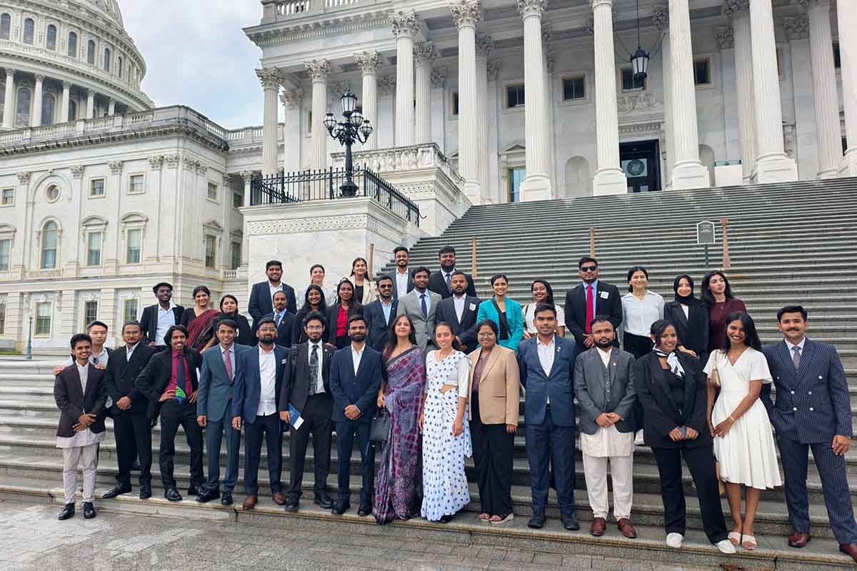 Group participants pose for a photo in front of the U.S. Capitol