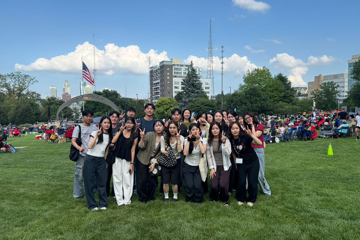 Group of students enjoying an outdoor concert at a park.