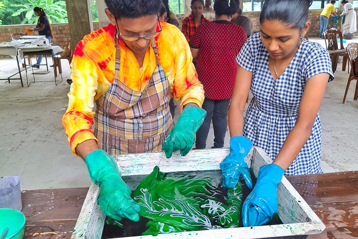 A man and woman practice local Sri Lankan art technique