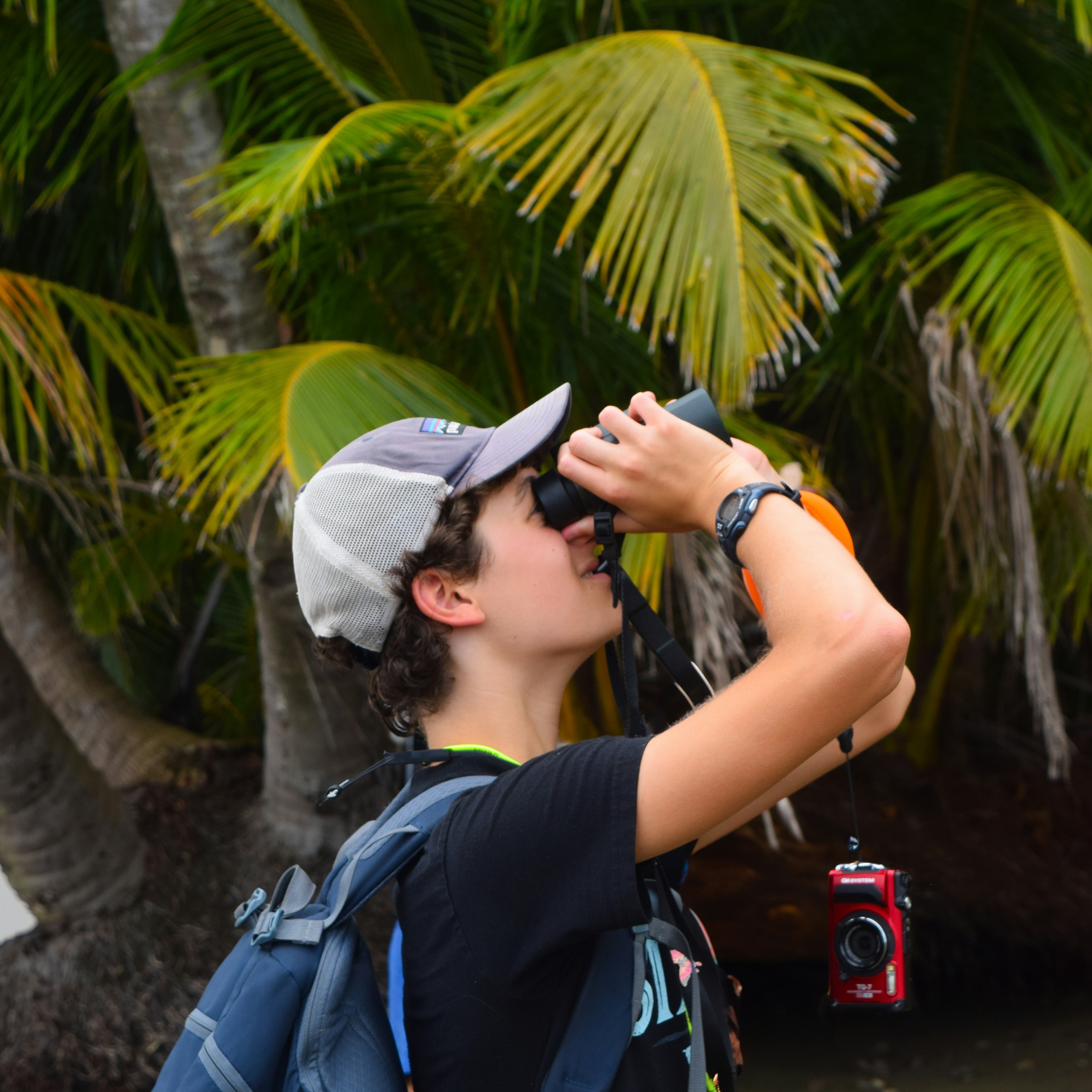 Traveler looking through binoculars on Uvita Beach in Costa Rica