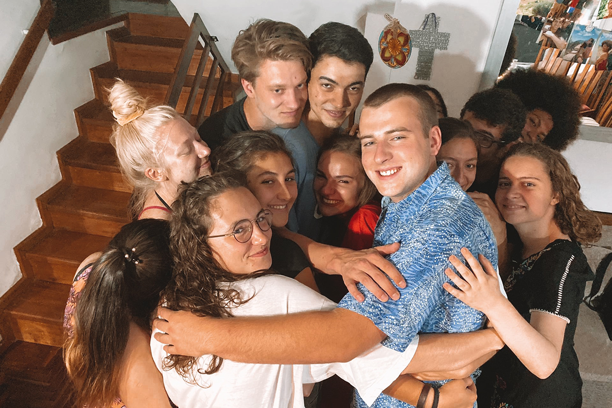 Group of college students in a group hug looking happy.