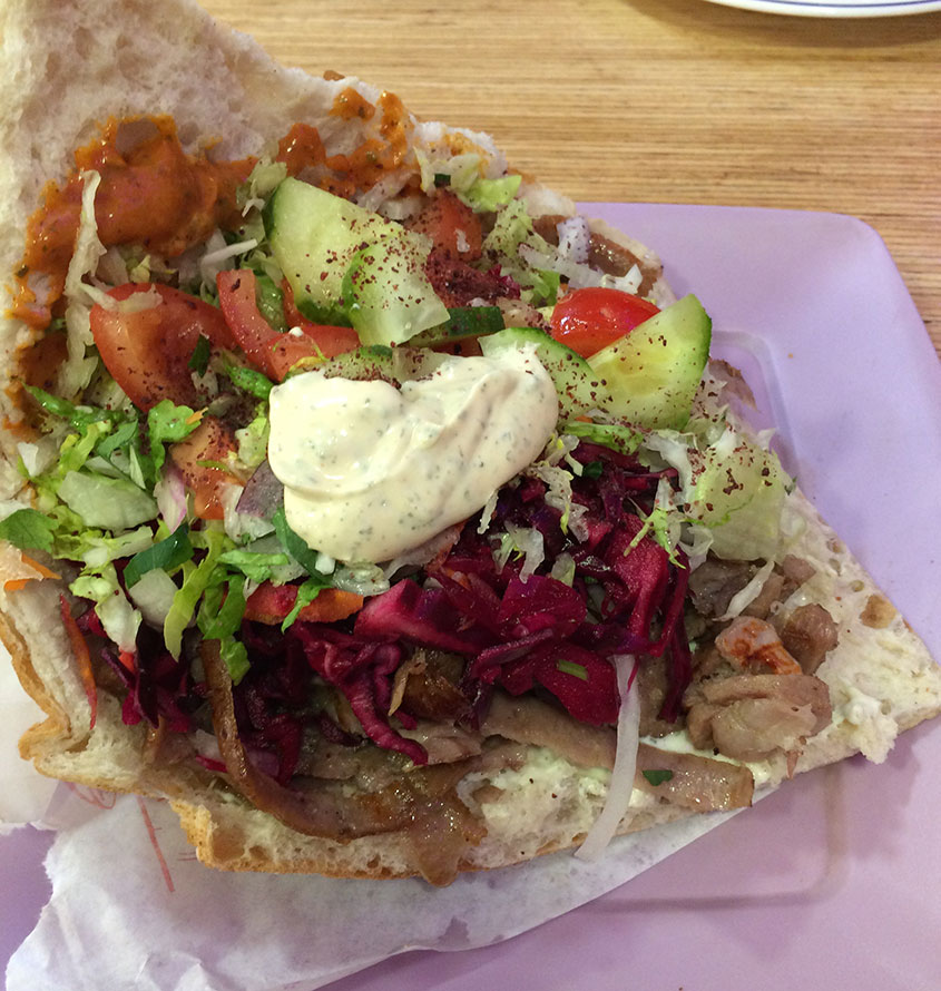 A pita with meat and fresh salad