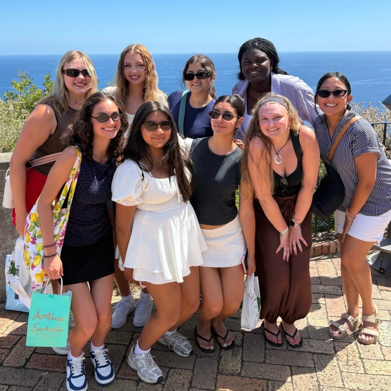 Group photo of students in front of the ocean in Italy