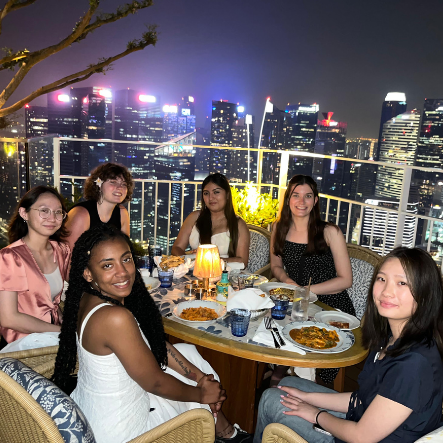 Group gathered with nighttime cityscape in background.