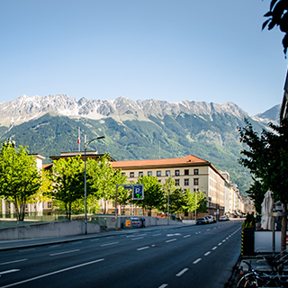 City street and buildings in front of a snowy mountain in Innsbruck, Austria