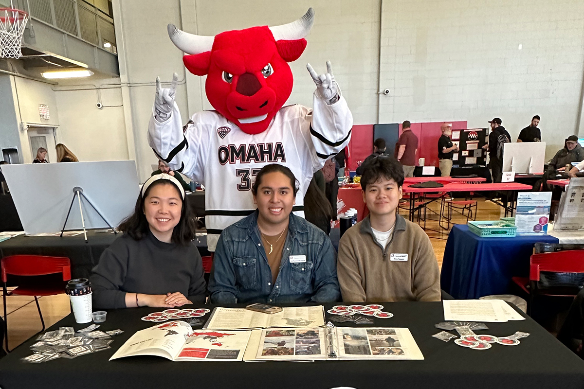 Three people sit at a table, Durango is behind them.