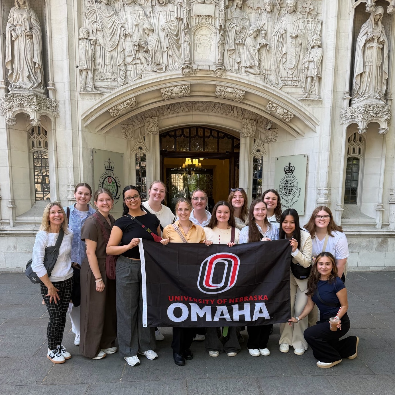 Group of students holding UNO flag in front of Supreme Court building in London