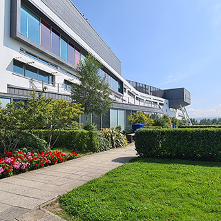 Photo of a modern building and manicured lawn on a college campus.