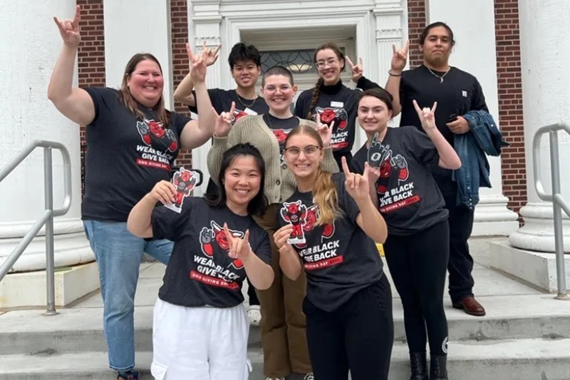 group throwing the horns on the Arts and Sciences building steps