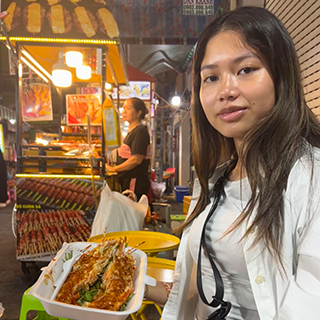 Young woman eating fried lobster.