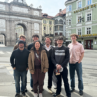A group poses together in Innsbruck, Austria with historic buildings in the background.