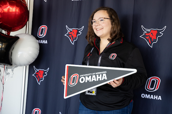 student holding a uno pennant