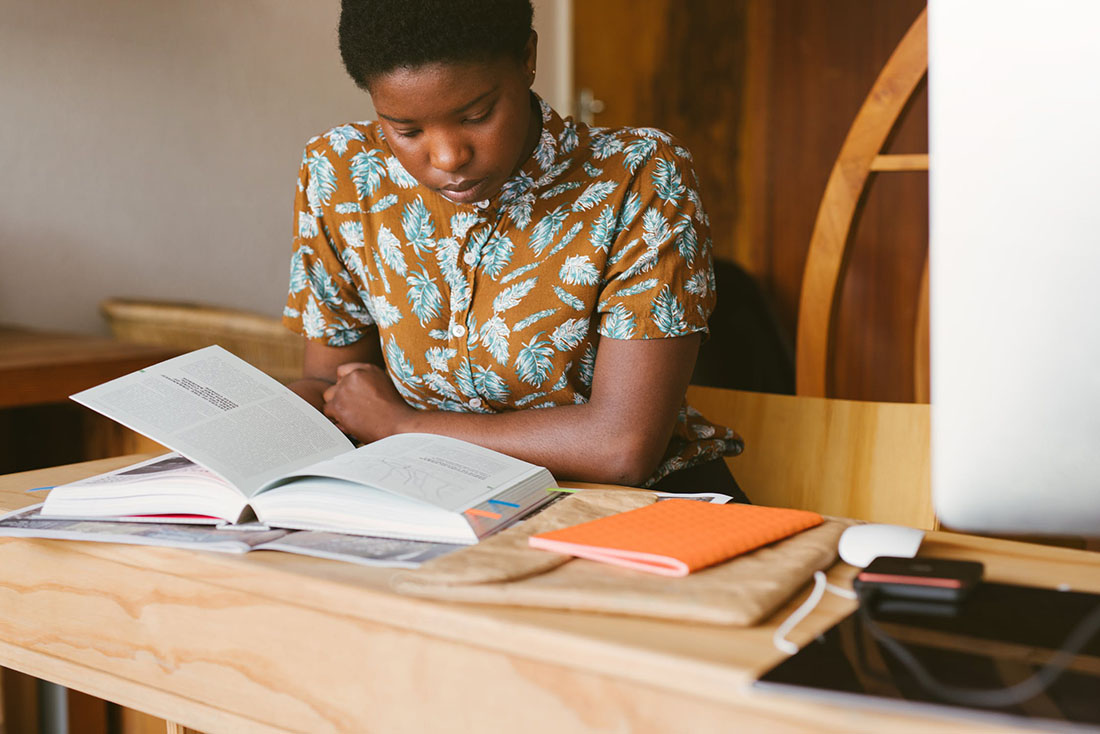 A student sits with books in front of them, studying.