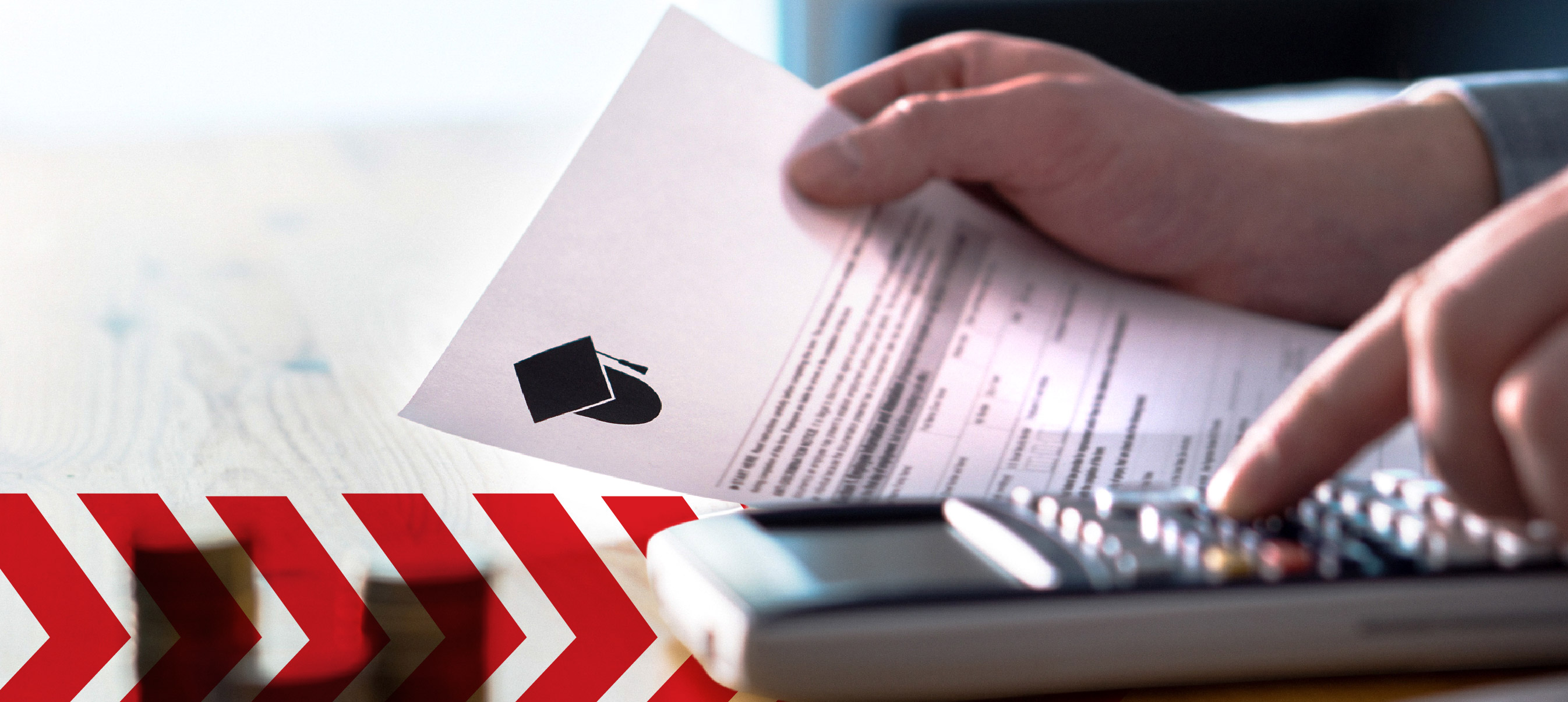 Person using a calculator while reviewing an education document