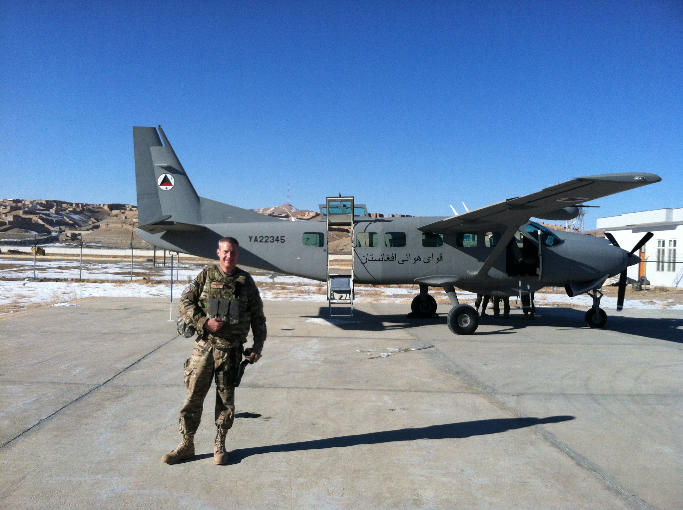 Skip Bailey in uniform standing in front of a Afghan Army Air Force Cessna Caravan 208-B aircraft.