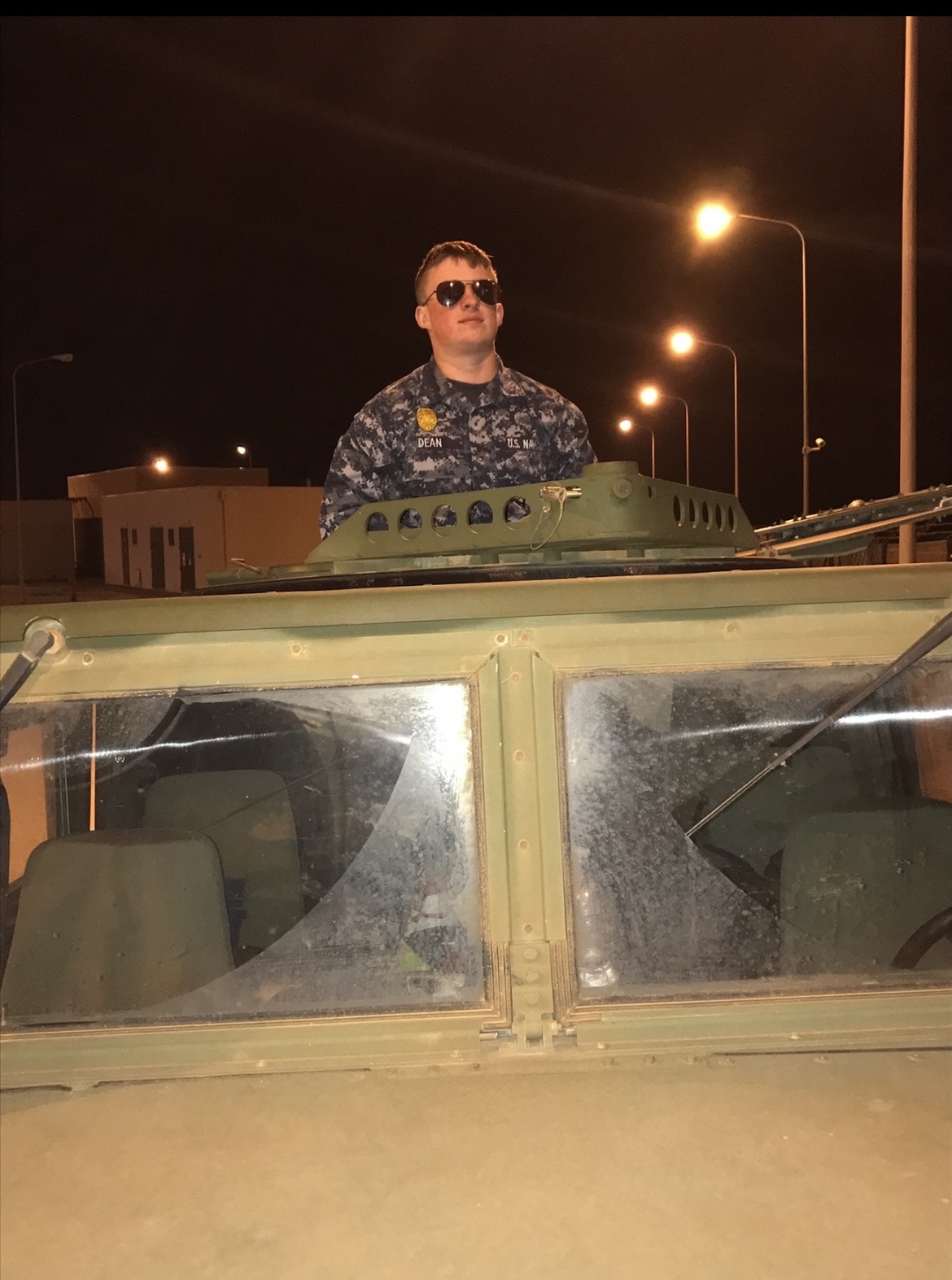 Veteran Coleton Dean in Naval uniform riding in a military tank.