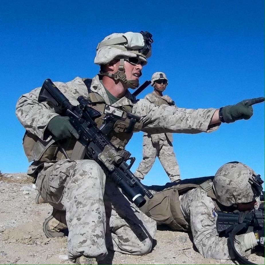 Photo of Jacob Mikesell in uniform on duty, pointing with 2 other service members.