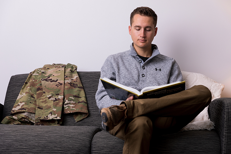 military student reading a book