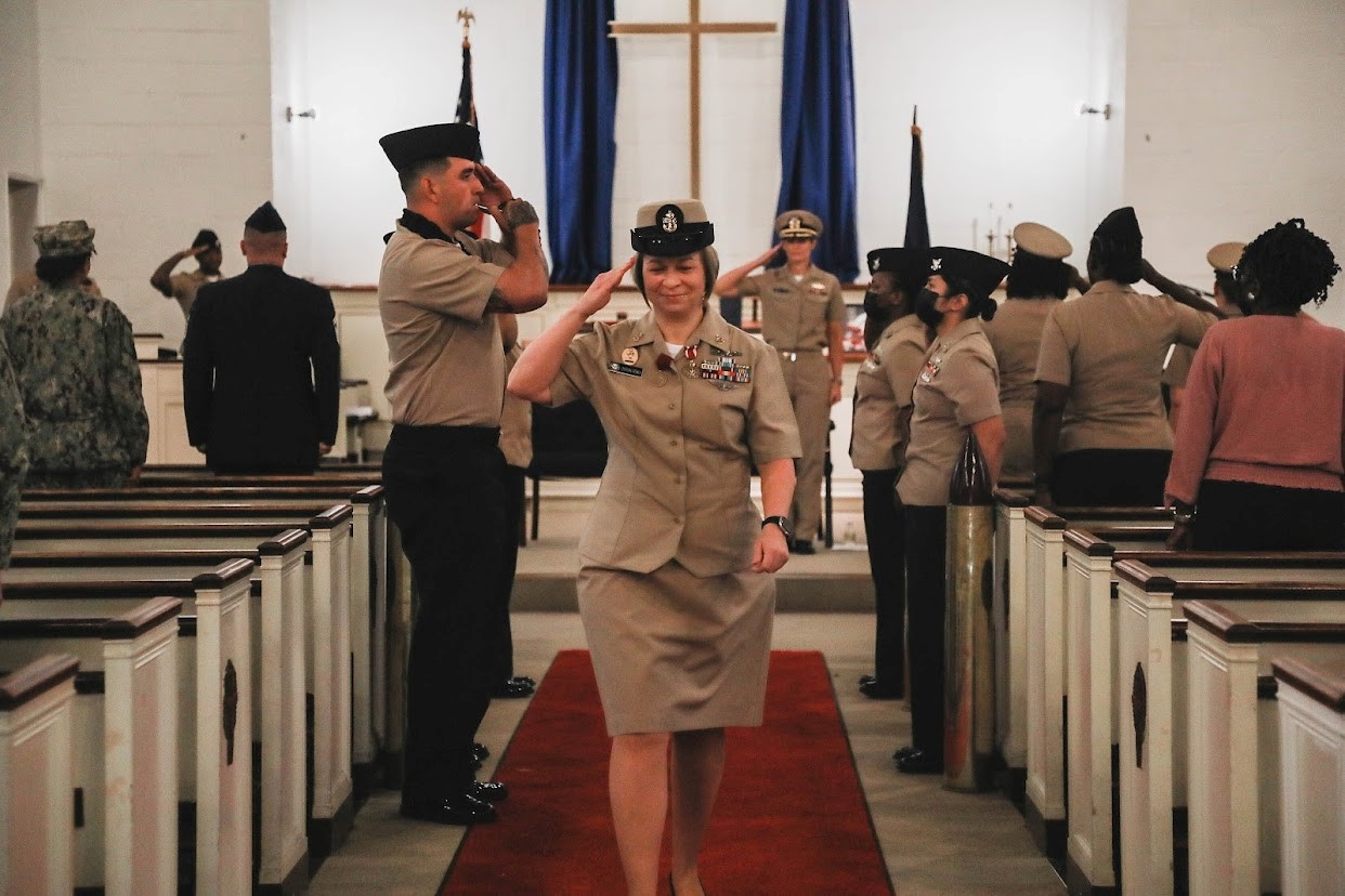 Lisa Vrtiska saluting in Naval uniform at retirement ceremony