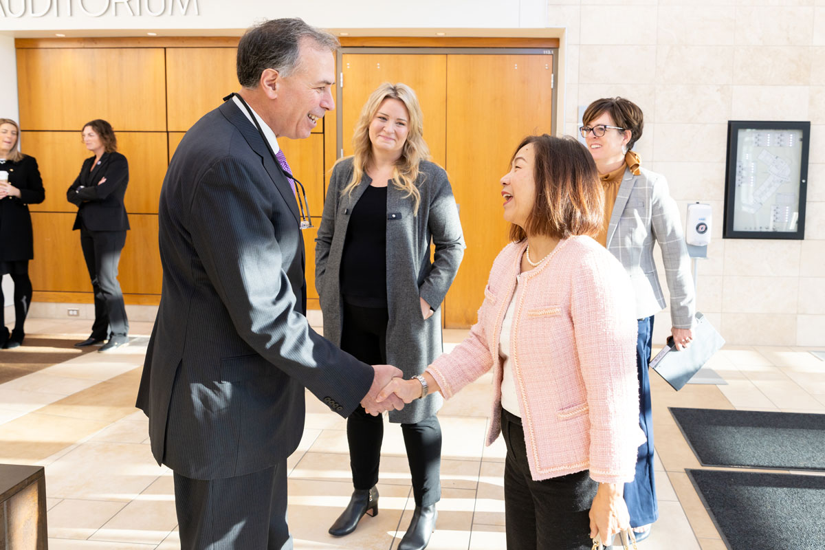 Dimitri Kusnezov shakes hands with UNO Chancellor Joanne Li