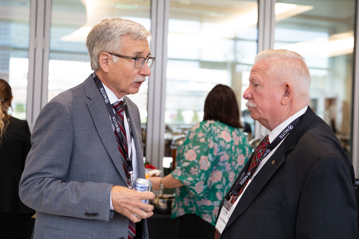 NCITE principal investigator Eric Frost speaks with a conference goer at ENVISION22. 
