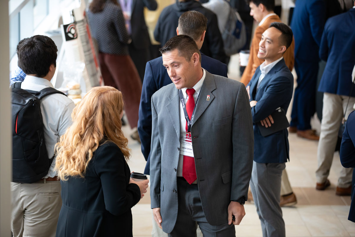 An NCITE researcher speaks with another conference goer at ENVISION22. 