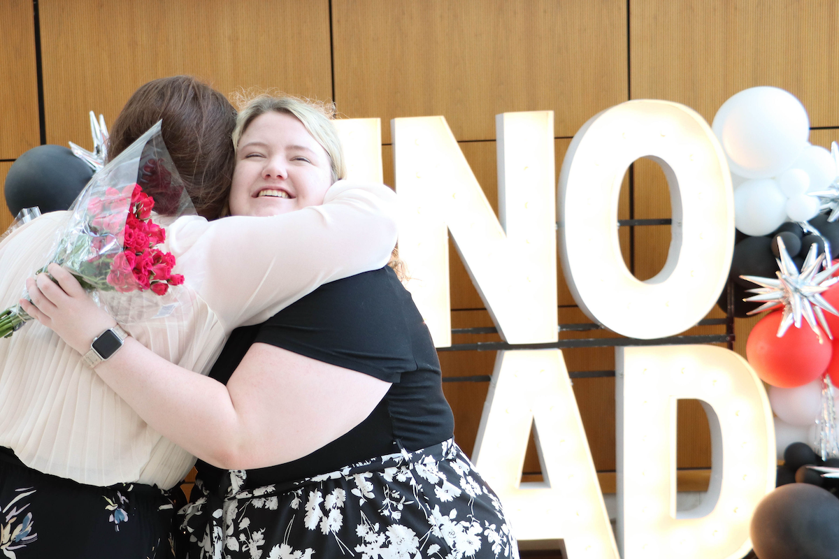 This photo shows two UNO students, both women, hugging each other just before a graduation event in May 2022.