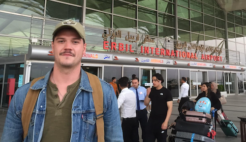 This is a photo of Austin Doctor, a man working at NCITE, standing in front of the Erbil, Iraq, airport.