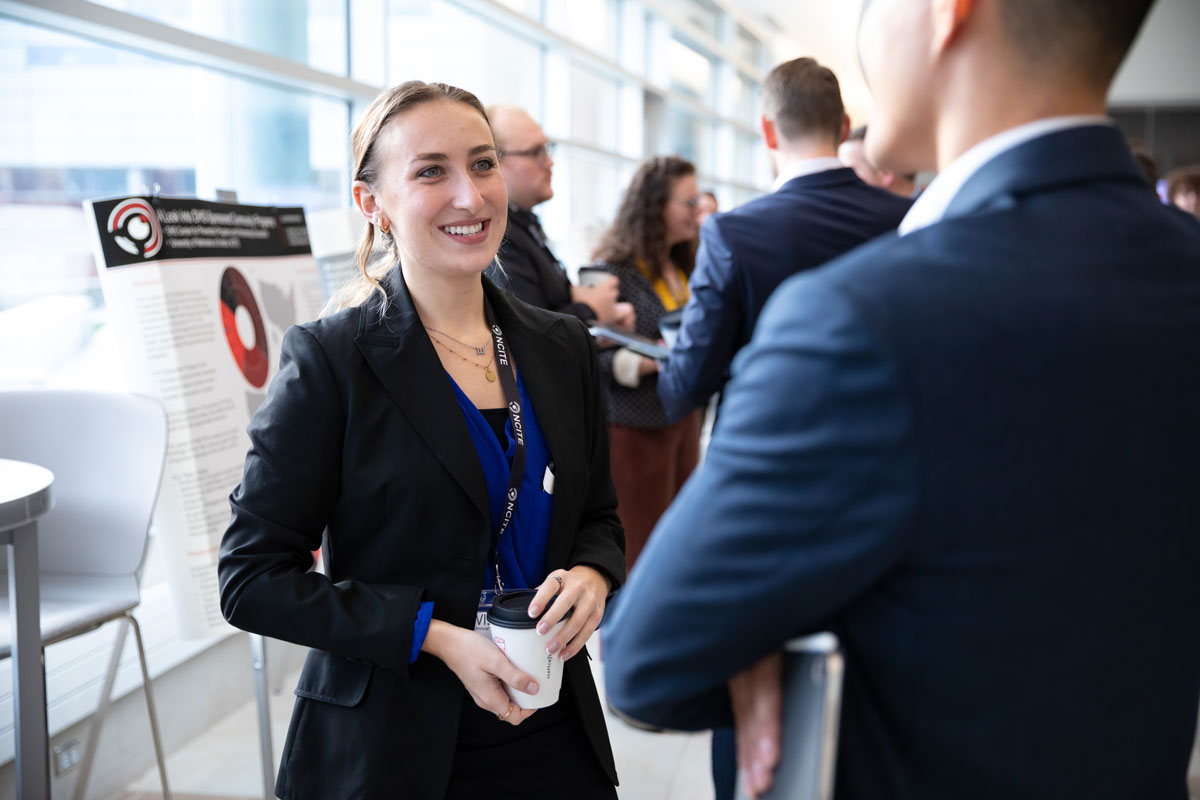 Female student discusses her research poster at ENVISION22. 