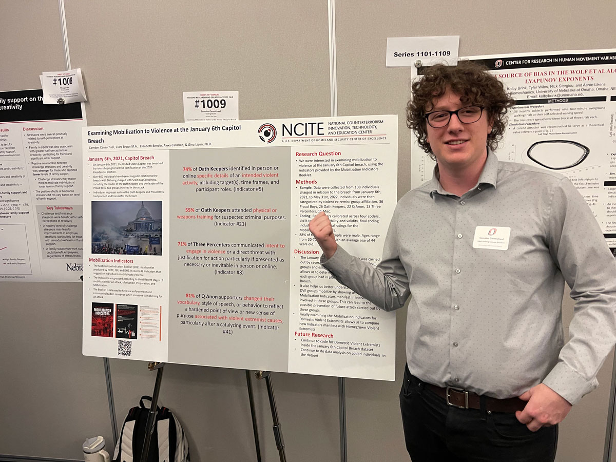 NCITE student Camden Carmichael stands in front of his research poster