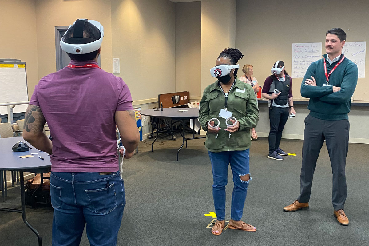 Austin Doctor watches as two people use virtual reality headsets. 