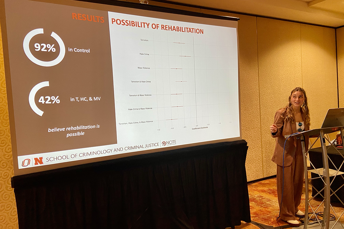 NCITE's Callie Vitro stands at a podium, presenting at this year's ASC Conference. 