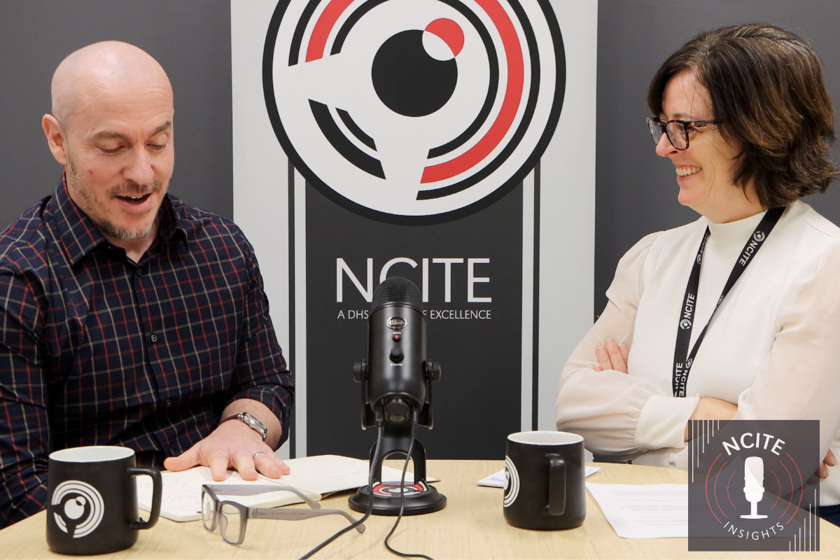 Sam Hunter, left, sits down with Erin Grace, right. In between them, in the background, is a banner displaying the NCITE birdie logo. 