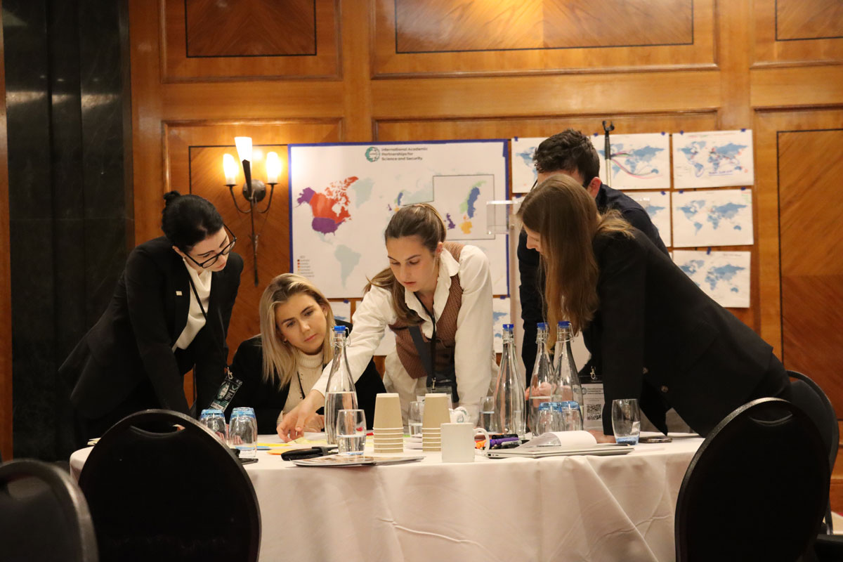 NCITE's Callie Vitro, surrounded by fellow researchers, points to a document on the table.