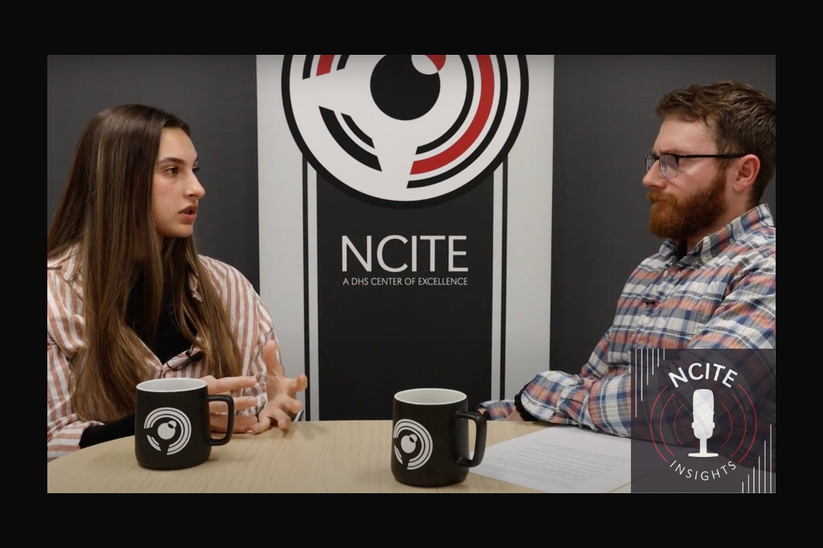 Callie Vitro and Blake Ursch are seated at the end of a table with the NCITE logo behind them. 