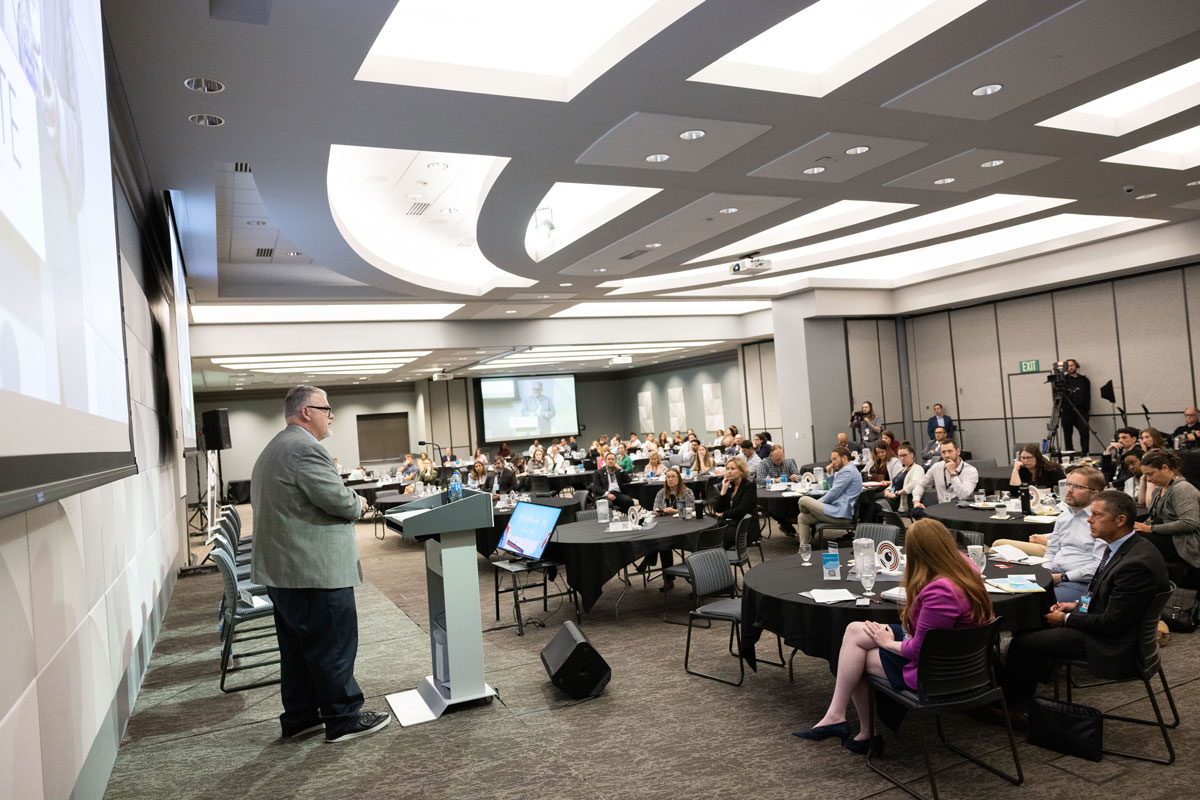 DHS Counterterrorism Coordinator Nick Rasmussen stands at a podium before the audience at the Scott Technology Center.