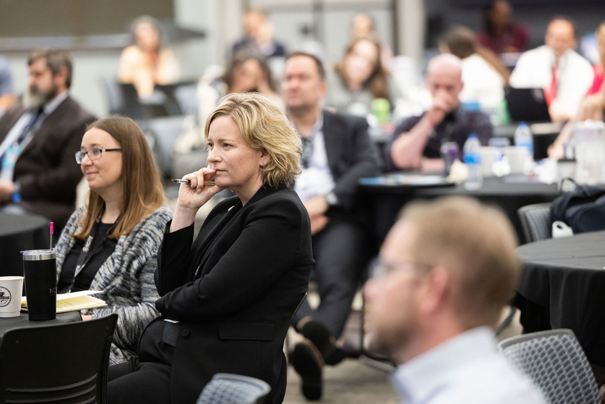 Gina Ligon intently watches a speaker at ENVISION24. Her hand is to her mouth. 