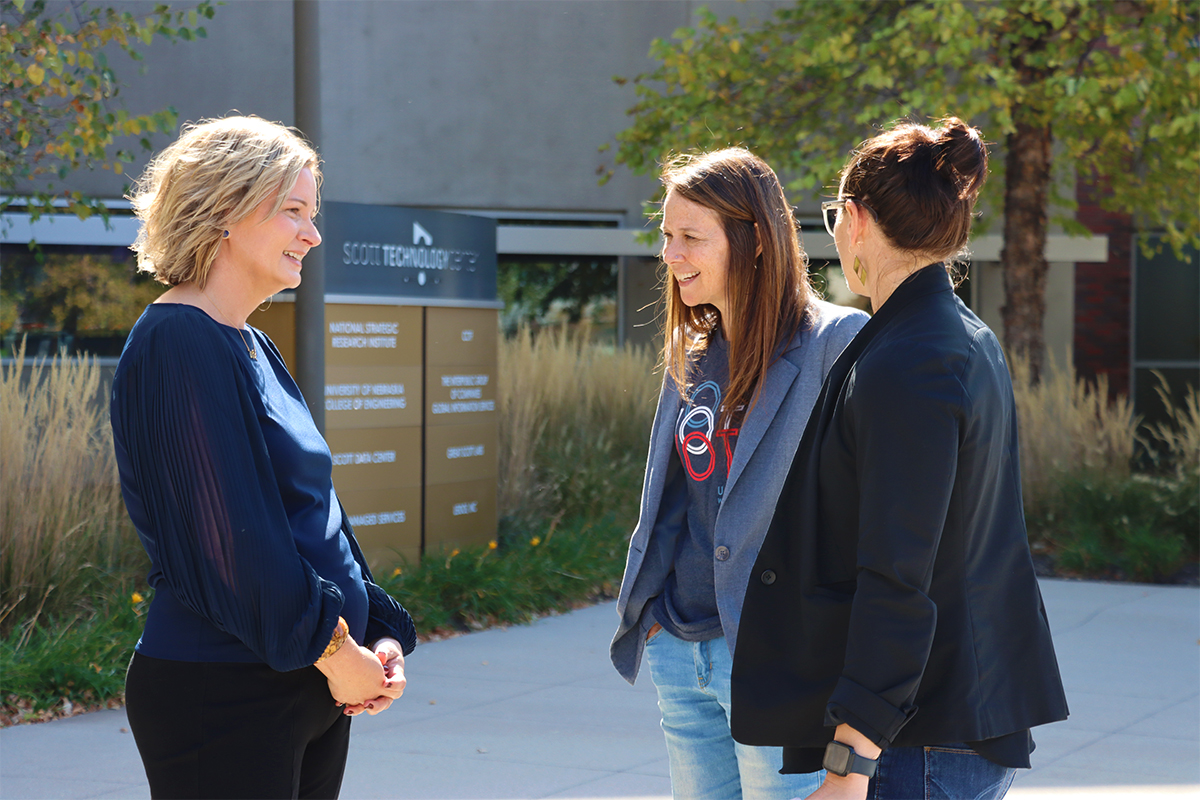 NCITE Director Gina Ligon greets CISA Director Jen Easterly outside. They are both smiling.