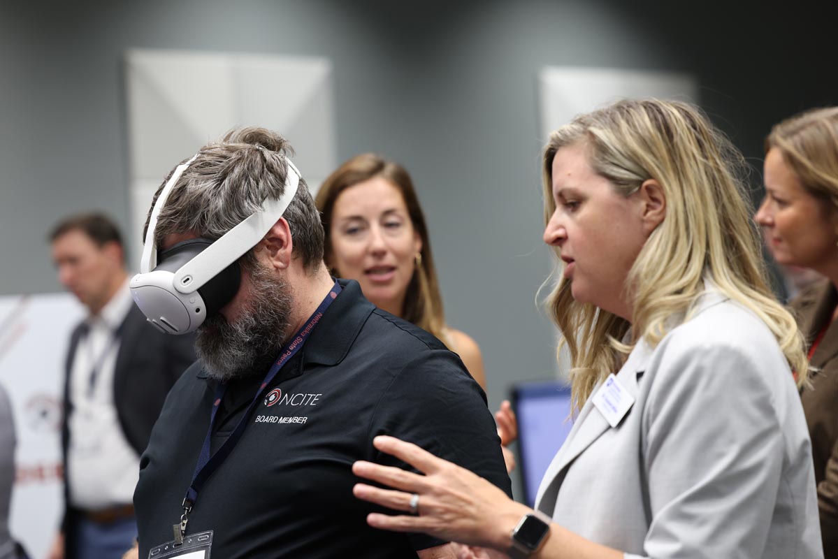 An attendee demonstrates a virtual reality headset during the technology showcase while others observe.