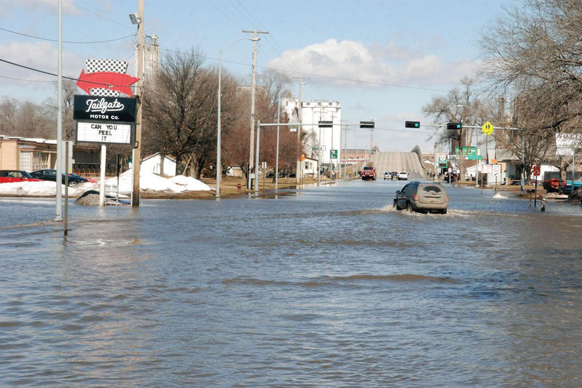 A vehicle plows through flood waters near Tailgate Motor Co., south of the Broad Street viaduct during the March flood in Fremont, Nebraska 