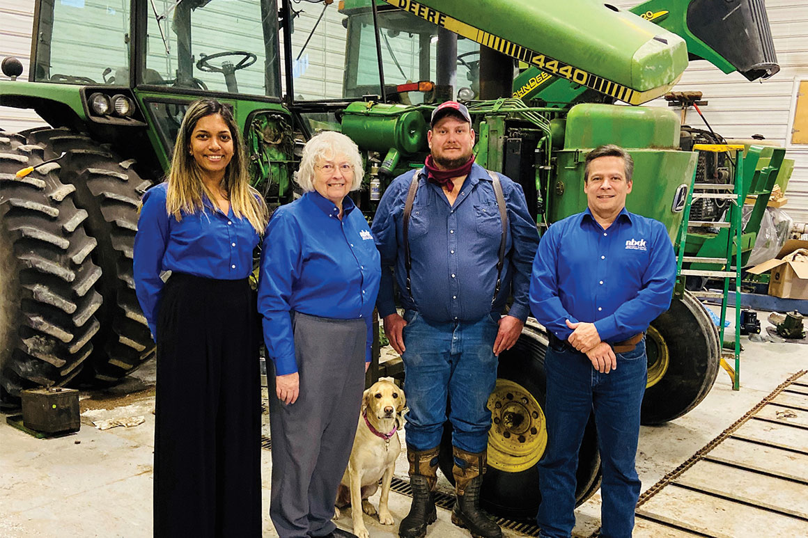 Davis Repair, LLC owner Nathan Davis pictured with NBDC consultants and Tessa the shop mascot dog.