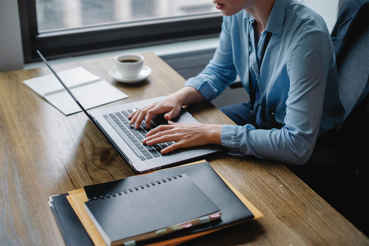 Person working on computer at desk with coffee