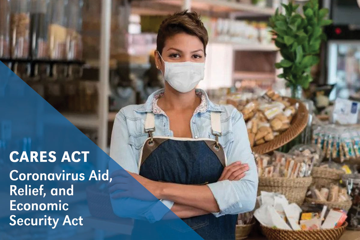 CARES Act: Boutique owner in mask stands in store with arms crossed.