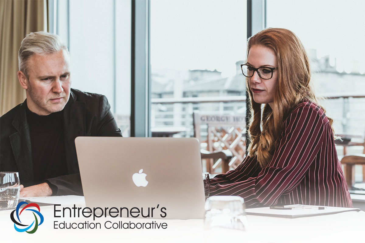 Man and Woman staring at Apple laptop