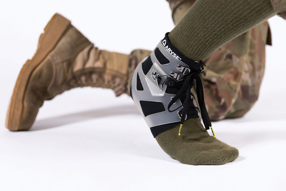Aryse ankle brace modeled by a person in military uniform.