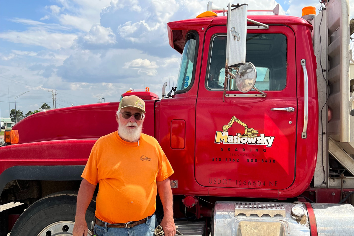 Bernie Maslowsky in front of company semi truck.